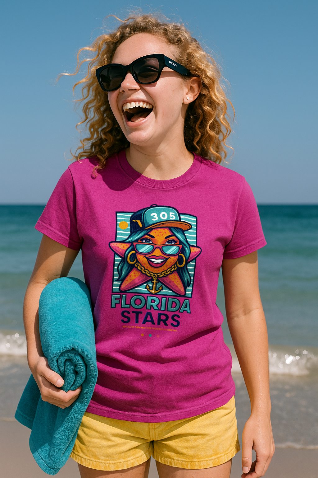 Blonde teenage girl standing on the shore of Miami Beach wearing a magenta Florida Stars tshirt by Made In Dade